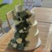 Hochzeitstorte - Weiße Rosen mit Sukkulenten zieren von unten bis oben die Torte, ganz oben ist der persönliche Cake Topper.