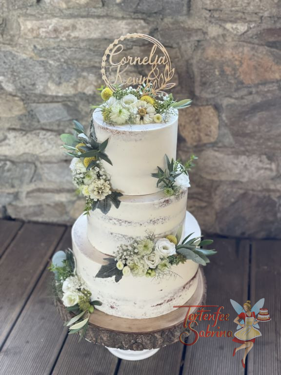Hochzeitstorte - Weiße Wiesenblumen und Rosen zieren diese dreistöckige Torte auf welcher ganz oben ein Caketopper ist.