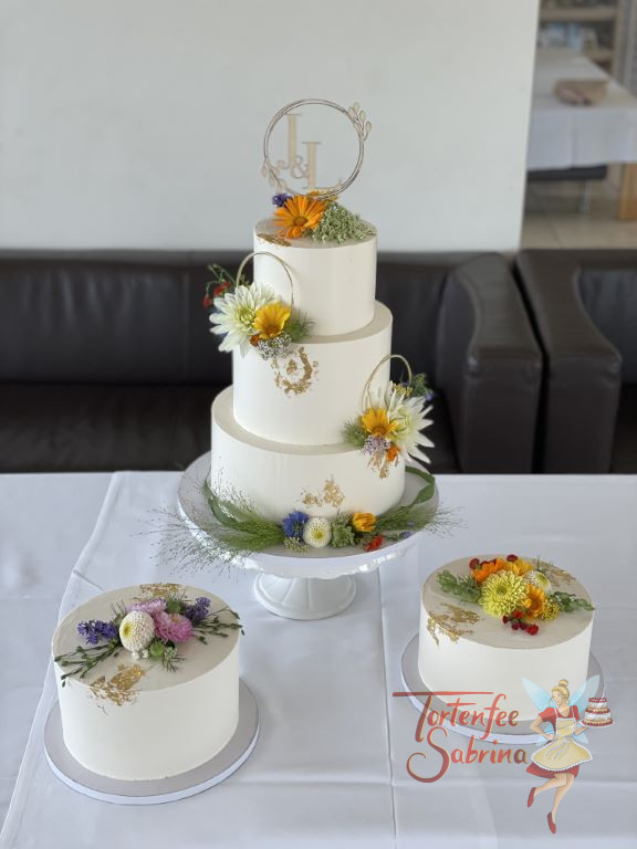 Hochzeitstorte - Wiesenblumen mit Loop verzieren neben dem Blattgold die Haupttorte und die zwei Side Cakes.