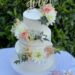 Hochzeitstorte - Wundervolle Blüten in den Farben Rosa, Lachs und Weiß wurden mit Eukalyptusblättern auf der Torte platziert.