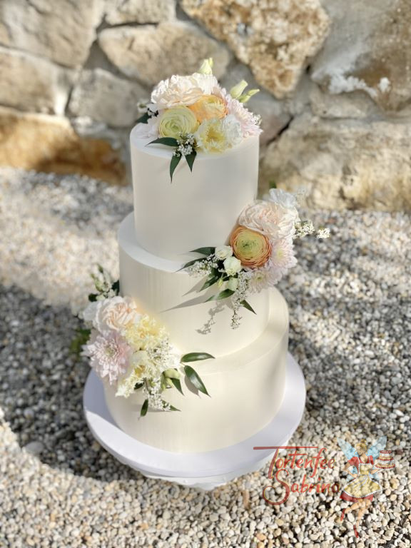 Hochzeitstorte - Zarte Blumenakzente sind bei dieser Hochzeitstorte der Blickfang auf der weiß eingestrichenen Torte.