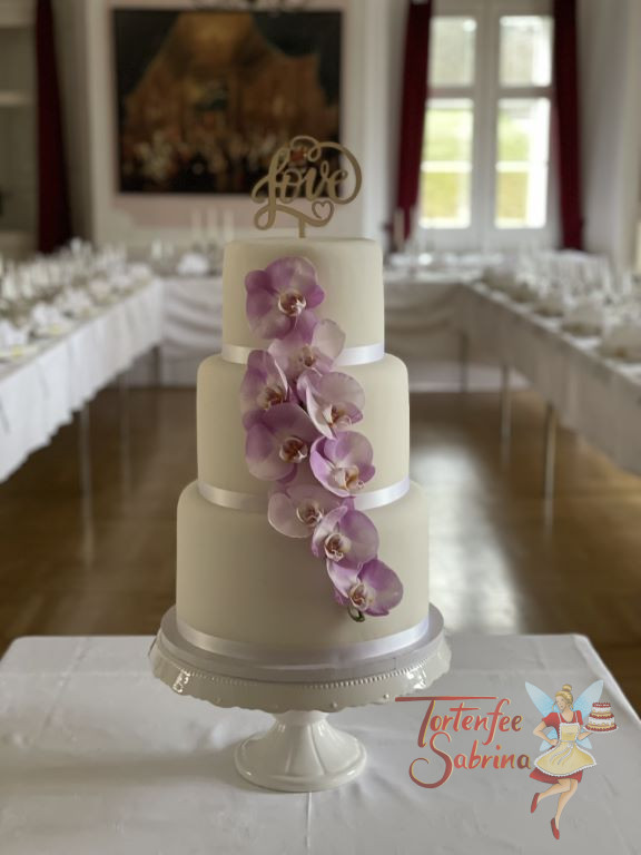 Hochzeitstorte - Zarte Orchideen in lila Farbe wurden an der vorderen Seite über alle drei Torten als Blickfang angebracht.
