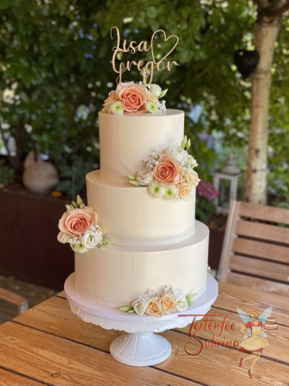 Hochzeitstorte - Zarte Rosenblüten mit Lisianhtus verzieren an mehreren Stellen die weiße dreistöckige Torte.