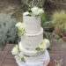 Hochzeitstorte - Zarte weiße Rosen mit feinen Blättern und kleinen Blüten zieren die Torte, ganz oben ist der personalisierte Caketopper.