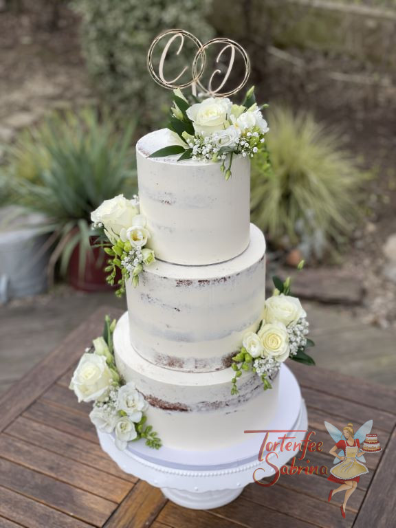 Hochzeitstorte - Zarte weiße Rosen mit feinen Blättern und kleinen Blüten zieren die Torte, ganz oben ist der personalisierte Caketopper.