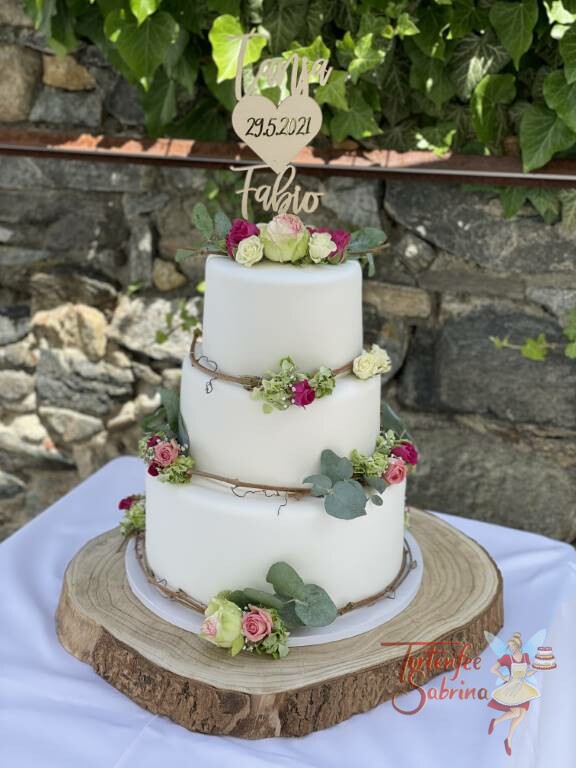 Hochzeitstorte - Zarter Blumenring mit verschieden färbigen Rosen auf einer Weinrebe, oben auf der Torte ist ein persönlicher Topper.