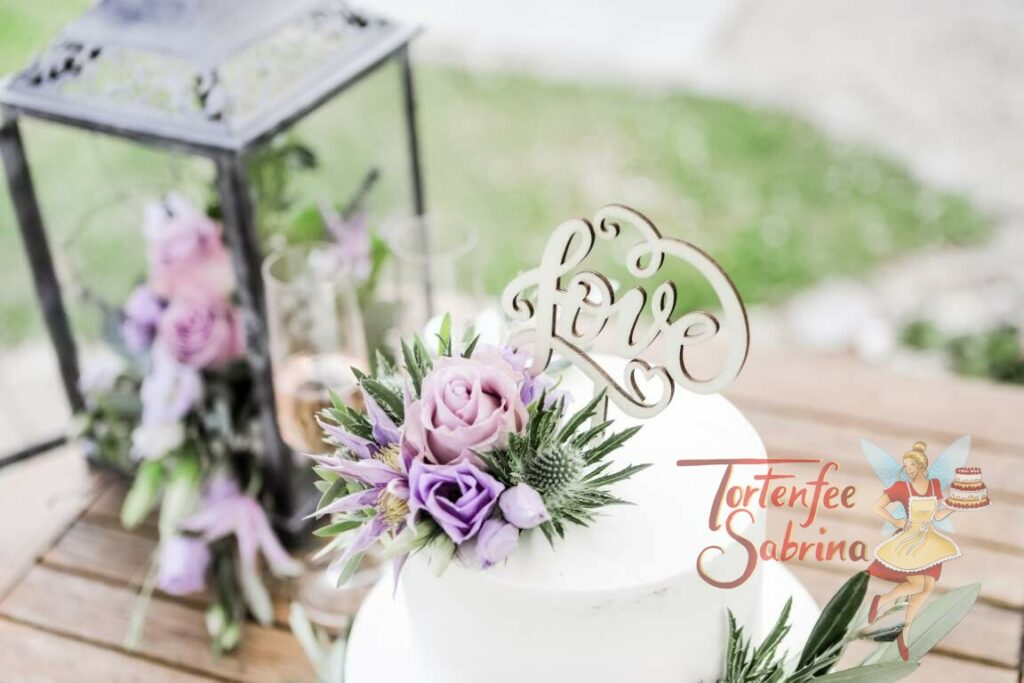 Hochzeitstorte - Zarter Lila Blumengruß bestehend aus Rosen, Clematis und Disteln verzieren die Torte, ebenso ein Cake Topper.