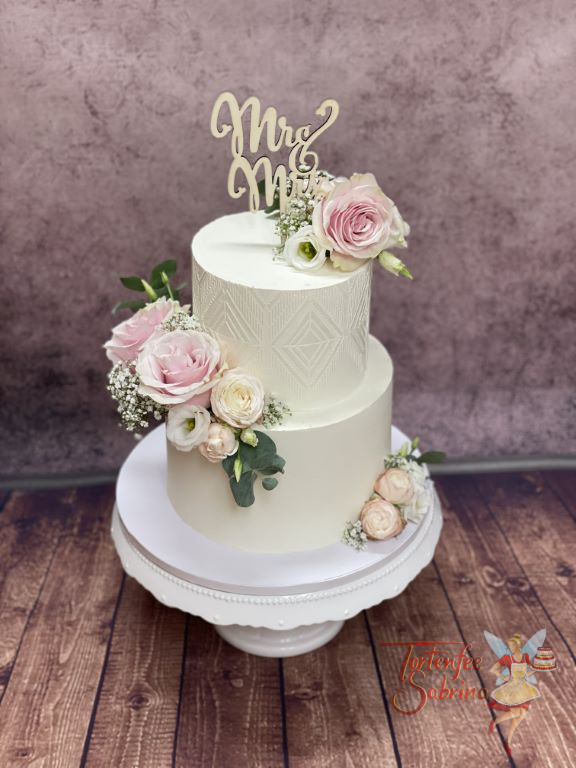 Hochzeitstorte - Zartes Muster mit Rosen in der Farbe rosa. Ganz oben zierte die Torte ein Caketopper aus Holz.