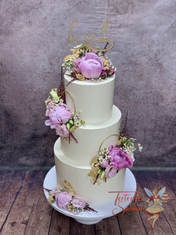 Hochzeitstorte - Zwei goldene Ringe verzieren neben dem Caketopper mit dem Unendlichkeitssymbol die dreistöckige Torte.