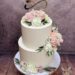 Hochzeitstorte - Zwei kleine Herzen verzieren neben der Schleife und den Namen die weisse zweistöckige Torte.