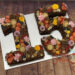 Number Cake und Geburtstagstorte Mädchen - Blumige 15ten mit dunkler Schokocreme und leckeren Süßigkeiten.