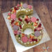 Number Cake - Köstliche Sechs würde mit unterschiedlichen Süßigkeiten und lila Macronen sowie Blumen verziert.