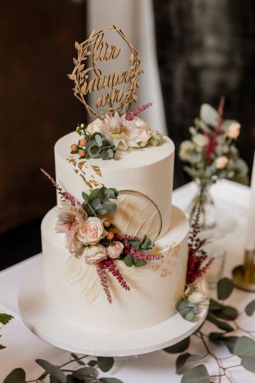 Sweet Table - Zarte Ringe mit dezentem Blumenschmuck zieren die zweistöckige Hochzeitstorte. Abschluß ist der Caketopper.