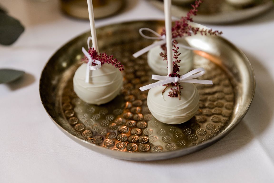 Sweet Table - Zarte Ringe mit dezentem Blumenschmuck zieren die zweistöckige Hochzeitstorte. Abschluß ist der Caketopper.