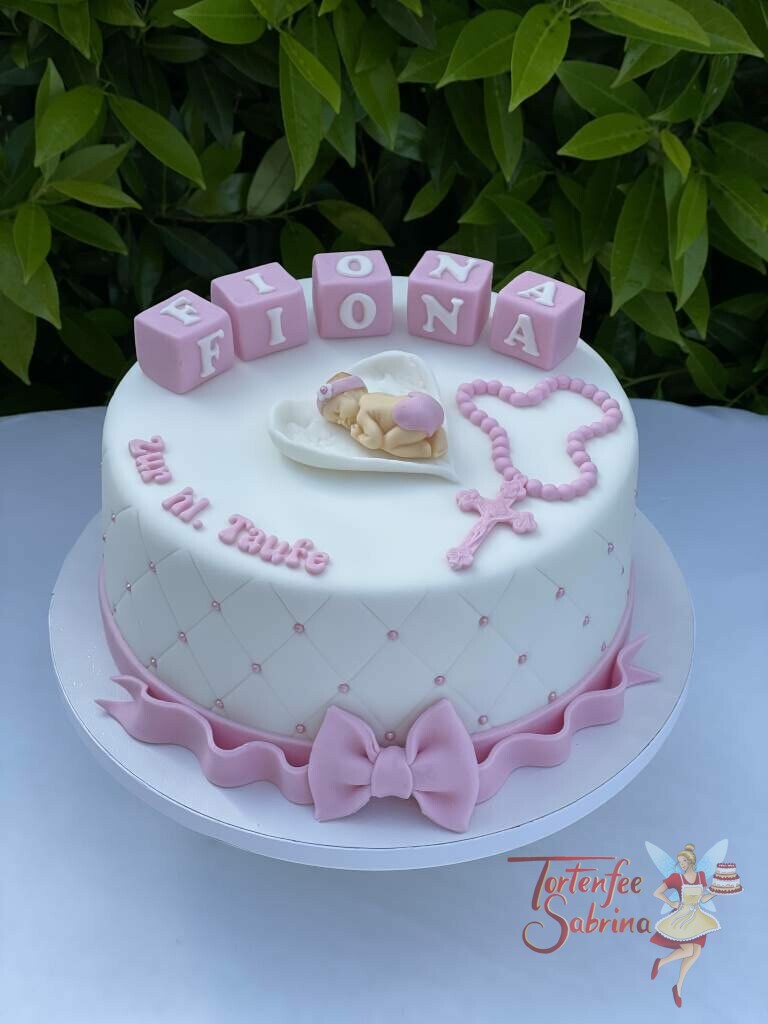 Tauftorte - Baby liegt in Engelsflügel neben einem rosa Rosenkranz, die Torte wurde noch mit einem Rautenmuster und Perlen verziert.
