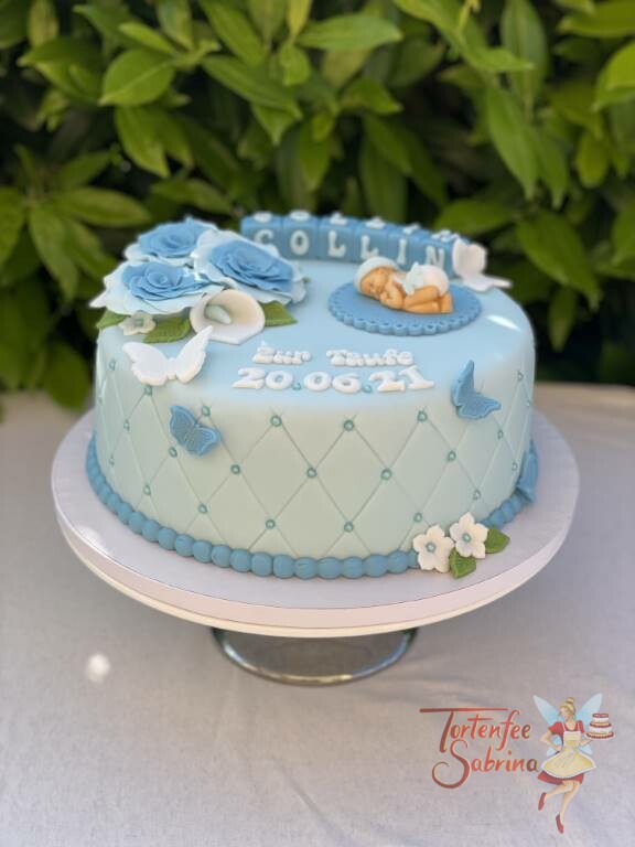 Tauftorte - Baby mit Windel und Haube liegt auf einer kleinen Decke, verziert ist die Torte mit blauen Rosen und Schmetterlingen