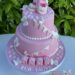 Tauftorte - Babyschuhe mit Wimpelkette, hier wurde die rosa Torte auch noch mit dem Namen auf Würfel verziert.