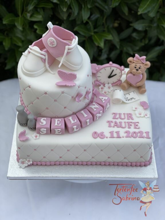 Tauftorte - Bär mit rosa Herzchen sitzt auf der Torte zwischen einer Uhr, Gewichten und einem Maßband, sowie den Namenswürfeln.
