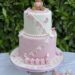 Tauftorte - Bärchen mit Herz und Schleife ganz oben auf der Torte, geschmückt mit einer rose und weißen Wimpelkette.