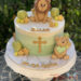 Tauftorte - Entzückender Löwe und ein Teddybär mit Herz verzieren diese mehrfärbige Torte neben dem goldenen Kreuz.