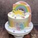 Tauftorte - Geschwungener Regenbogenauf der Torte wiederspiegelt die Farben welche seitlich auf der Torte aufgebracht sind.