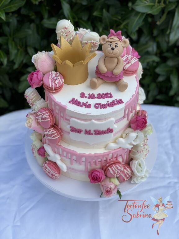 Tauftorte - Goldene Korne und Bärchen mit rosa Schleife sitzen oben auf der Torte umgeben von vielen Süßigkeiten.