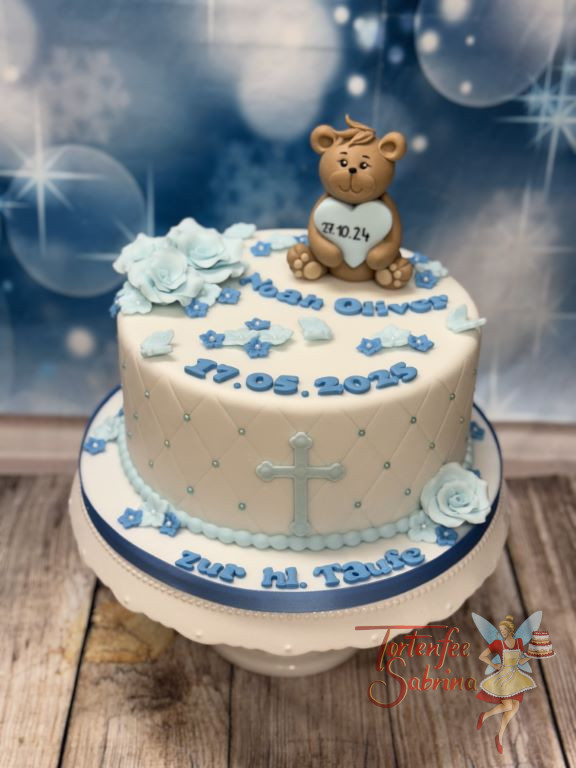 Tauftorte - Kleine blaue Rosen und ein Teddybär mit blauem Herz verzieren oben die Torte, seitlich zieren sie Zuckerperlen.