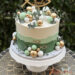 Tauftorte - Kleine goldene Kugeln verzieren neben grünen und weissen Kugeln die mehrfärbig eingestriche Torte.