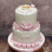 Tauftorte - Rosa Buchstabenwürfel mit dem Namen des Taufkindes zieren den unteren Teil der Torte, ganz oben liege ein Baby im Herz.