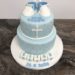 Tauftorte - Schüchen in blau. Die Torte wurde mit einem Rautenmuster und Perlen verziert. Sowie einem Kreuz in weiß und Würfeln mit dem Namen.