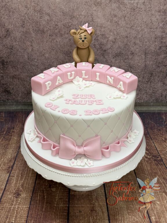 Tauftorte - Süßer brauner Teddybär mit rosa Schleife auf dem Kopf, weiters ist auch eine rosa Schleife auf dem unteren Ende der Torte.