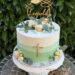 Tauftorte - Viele kleine Fische aus Holz verzieren bei dem personalisierten Caketopper die mehrfärbig grüne Torte.
