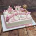 Tauftorte - Zwei rosa Schuhe verzieren neben dem niedlichen Teddybären mit Herz und dem seitlichen Muster die Torte.