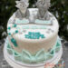 Tauftorte - Zwei Tierfreunde, ein Fuchs und ein Löwe in der Farbe grau zieren die Torte, welche seitlich mit Perlen verschönert wurde.